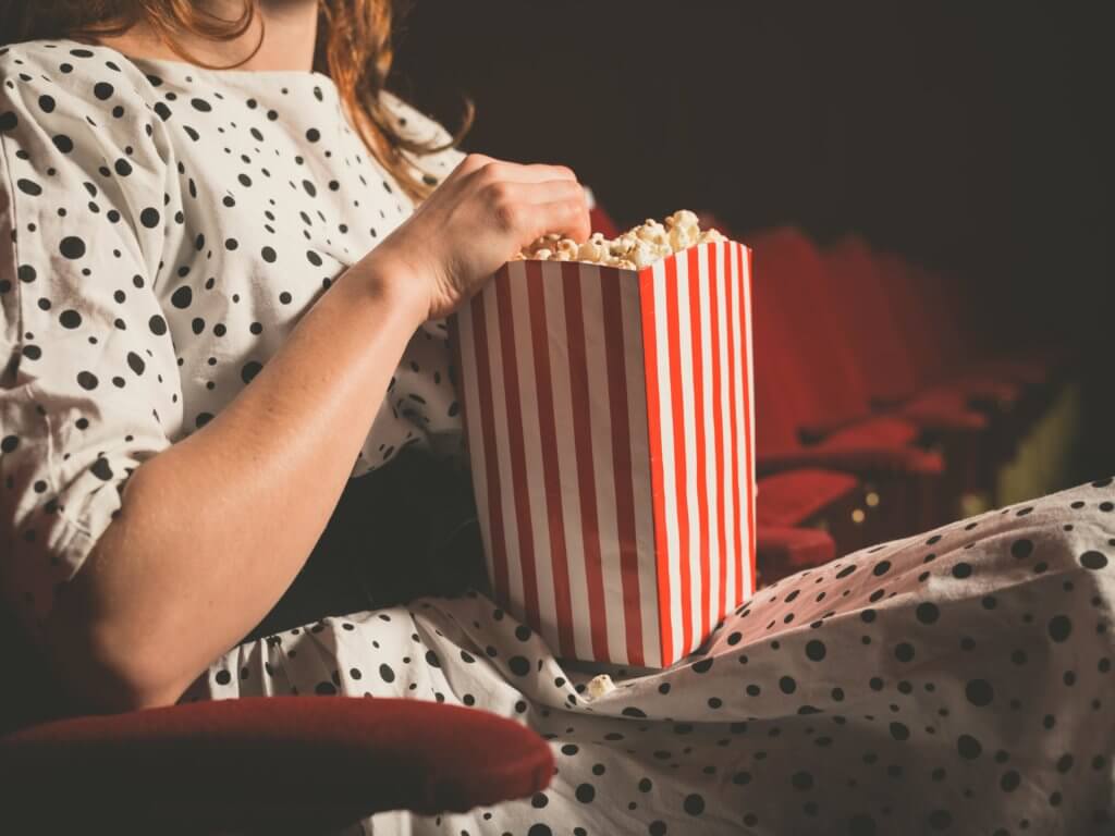best movie theaters in Austin: woman eating popcorn