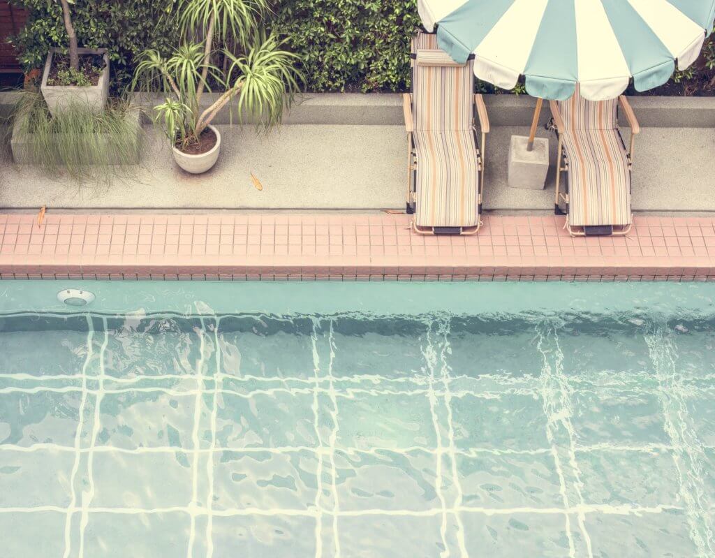 best hotel pools in austin: lounge chairs and umbrella by pool