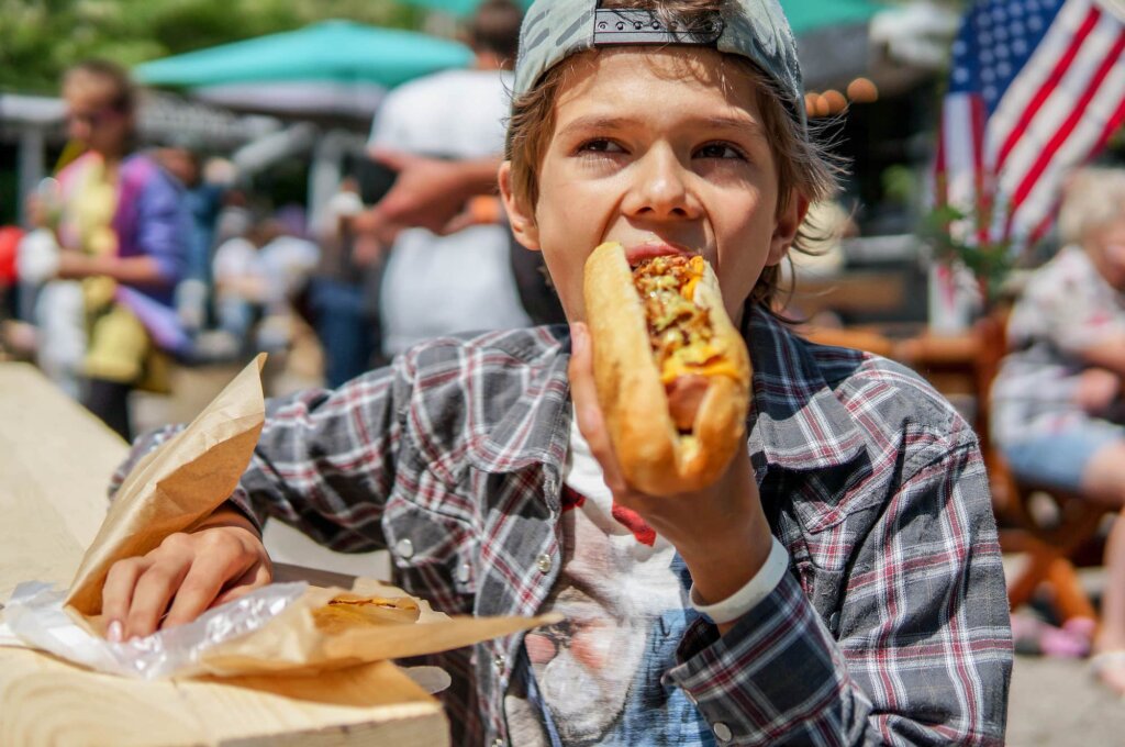 best hot dogs in austin: young boy eating a hot dog