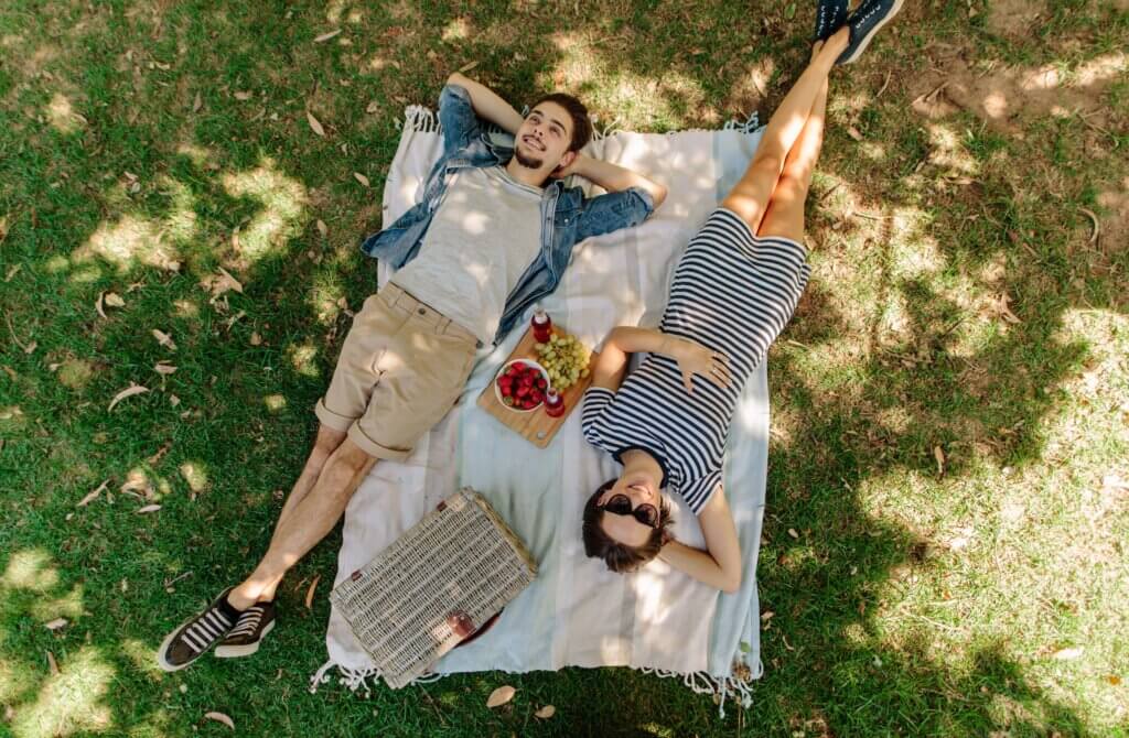 couple laying on blanket in the park